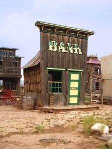 Featured is a photo of a bank from a ghost town in the American West (in the vicinity of Utah's Zion National Park).  Photographer unknown.